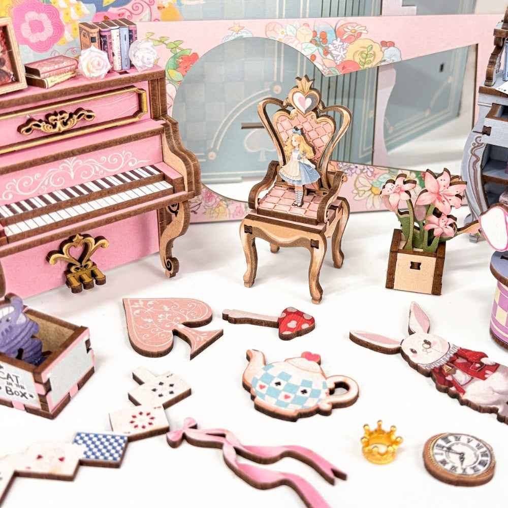 Alice's Tea Party Diary miniature piano, chair, teapot, playing cards and rabbit pieces laid out.