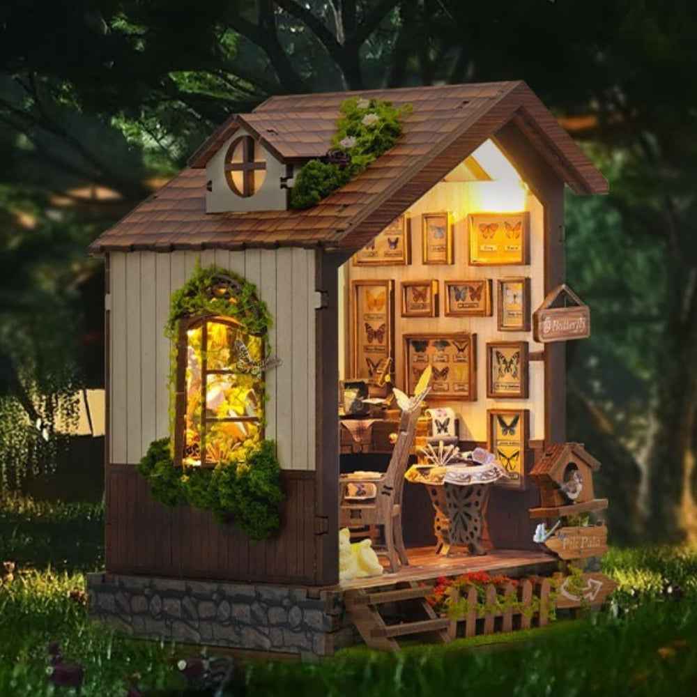 Butterfly House miniature cottage with a pitched roof, lit windows and butterfly displays inside.