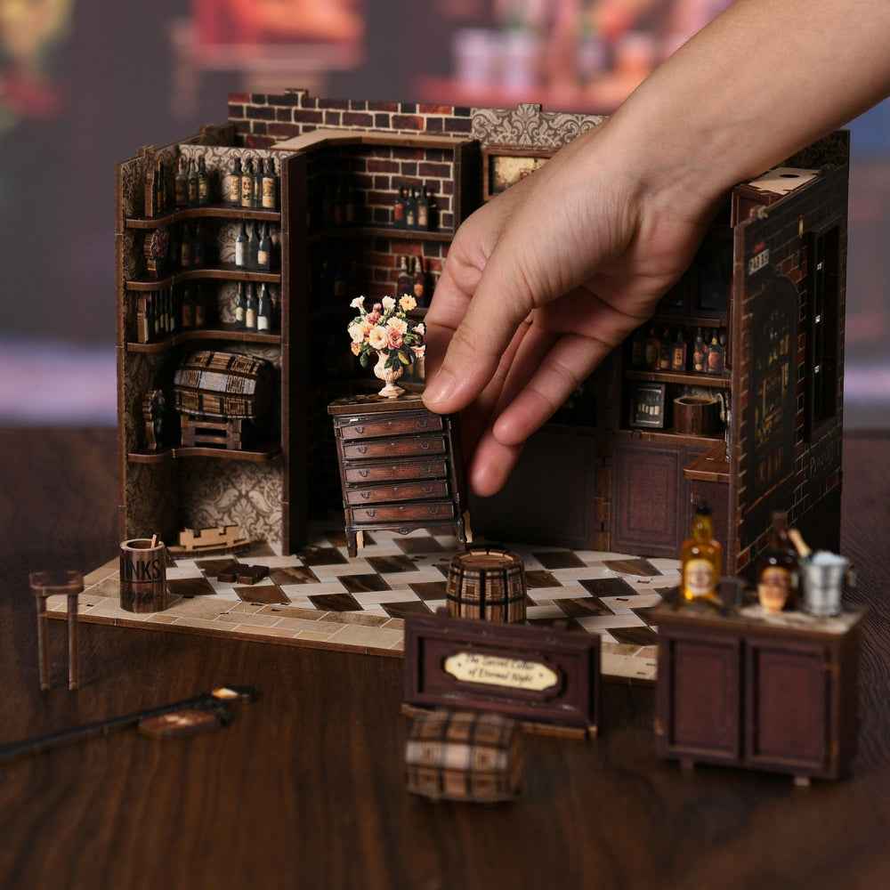 Hand placing a cabinet inside the Corner Tavern miniature pub.