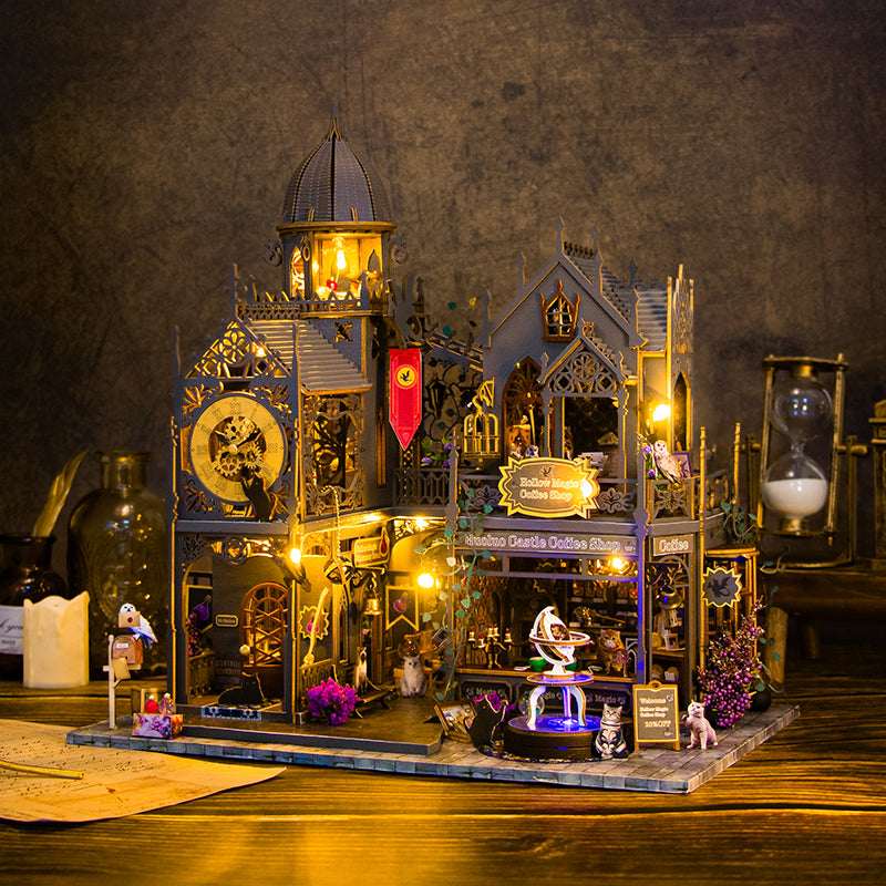 Hollow Magic Coffee Shop illuminated miniature streetscape with a clock tower and pointed roofs.