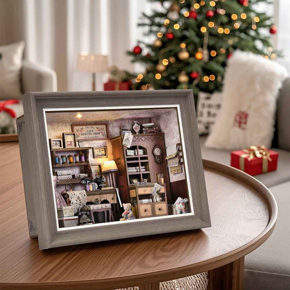 Lily Sewing Shop miniature frame displayed on a table beside a Christmas tree.