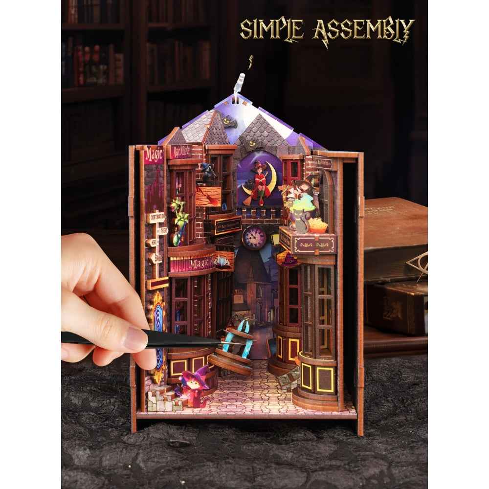 Hand assembling Magic Alley with a side panel open to expose the miniature street.