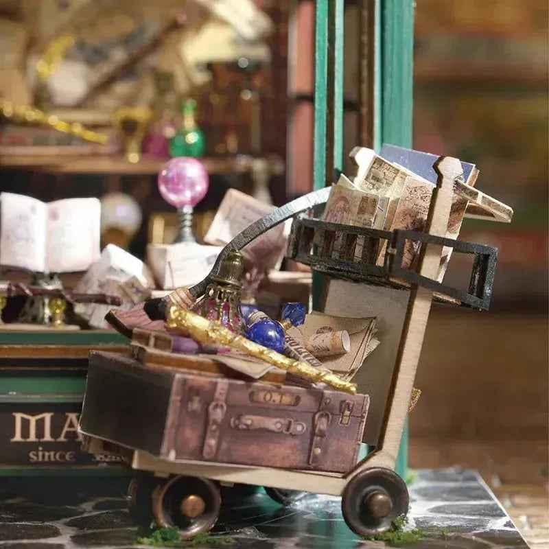 Miniature luggage trolley carrying books, a chest and a wand in the Magic House book nook.