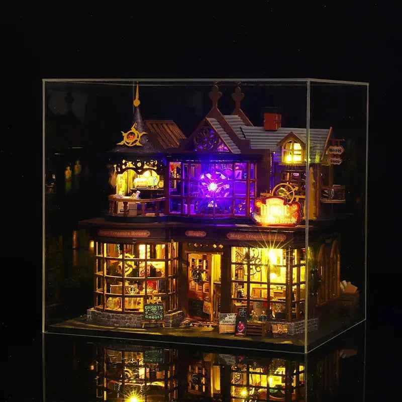 Illuminated Magic Treasure House inside a clear display case against a dark background.