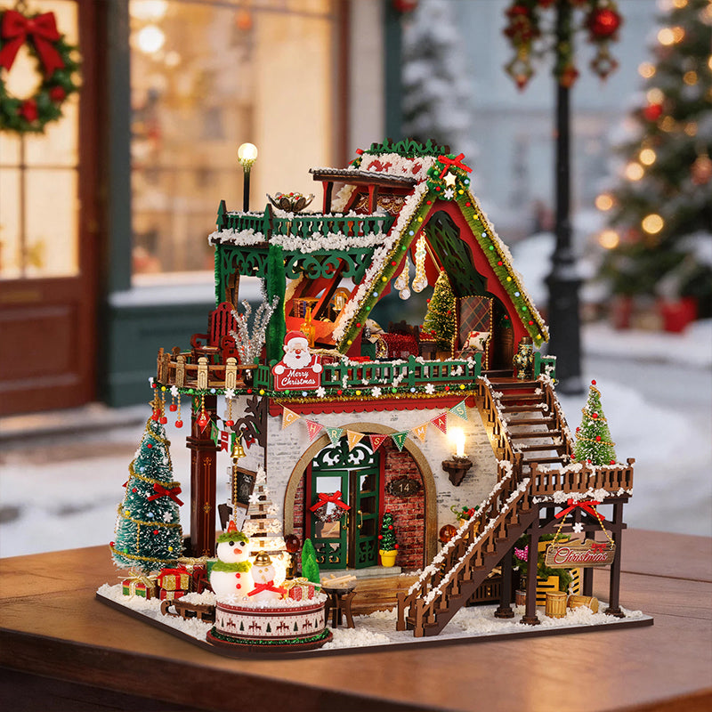 Snowy Christmas Lodge miniature house with green trim, snowy roofs and festive decorations.