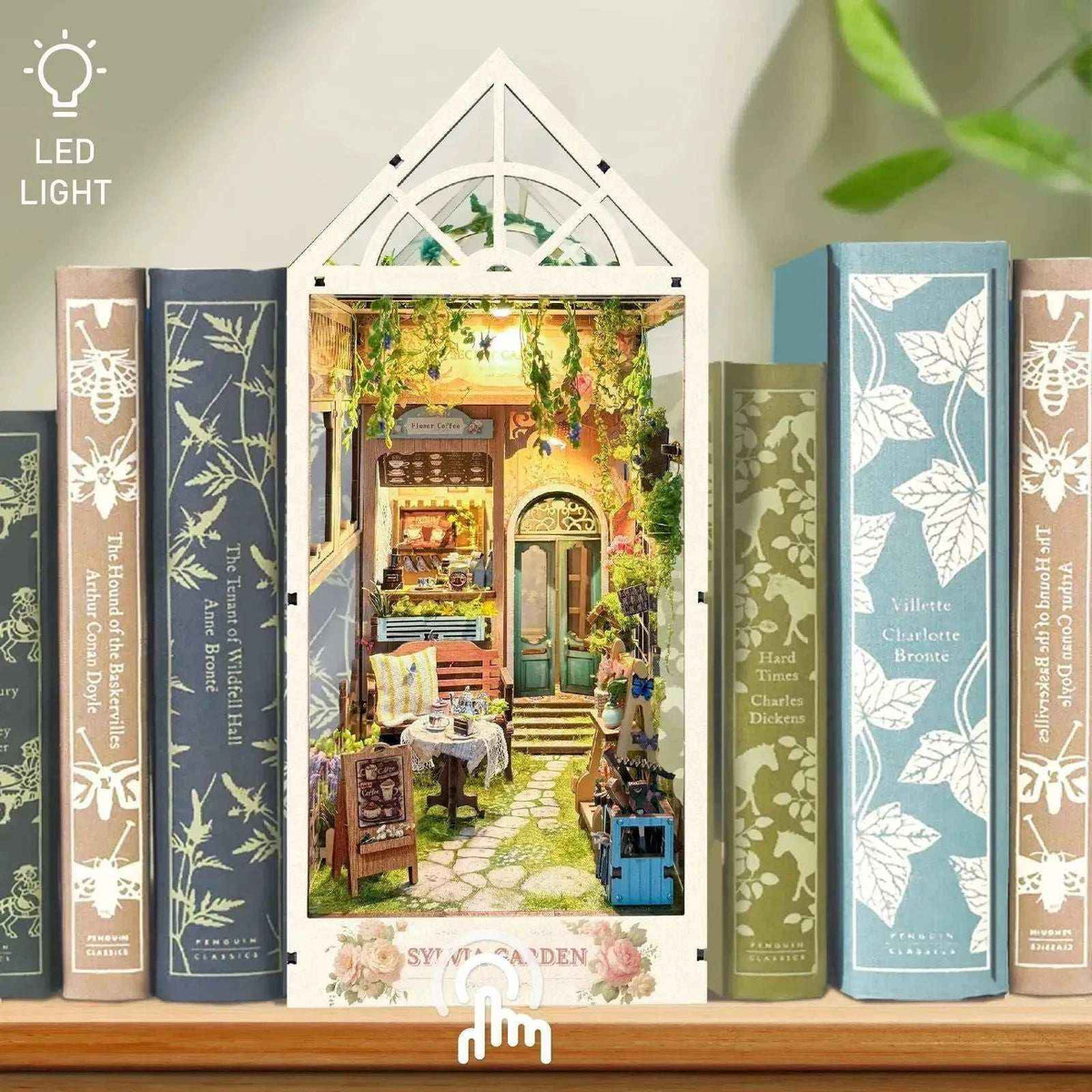Sylvia's Garden book nook between books, with a white greenhouse frame and pointed glass-style roof.