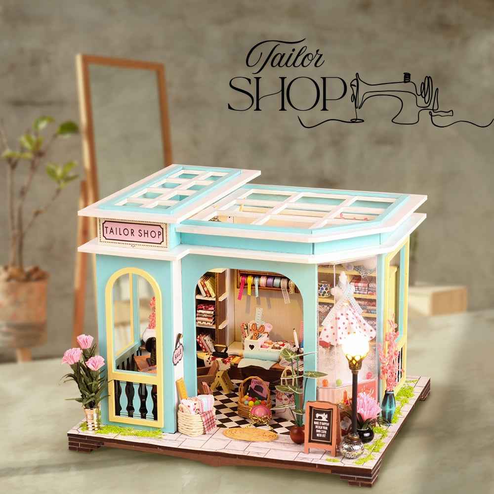 Tailor Shop miniature building with turquoise trim, sewing supplies and a dress in the window.