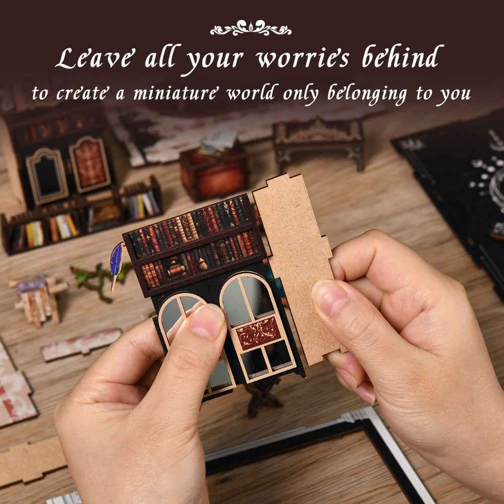 Hands assembling a wall panel with miniature shelves for The Realm of the Magic Book.