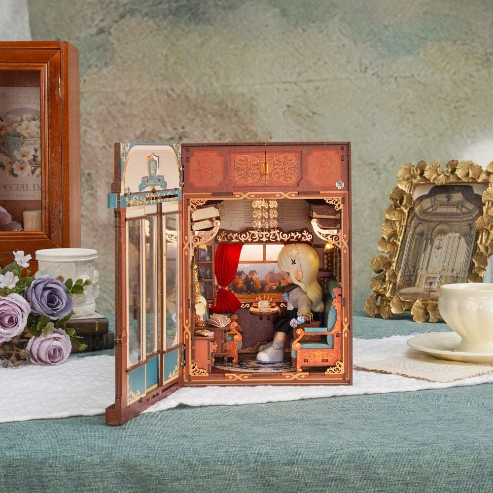 European Travel train cabin with open doors and a seated miniature figure inside.