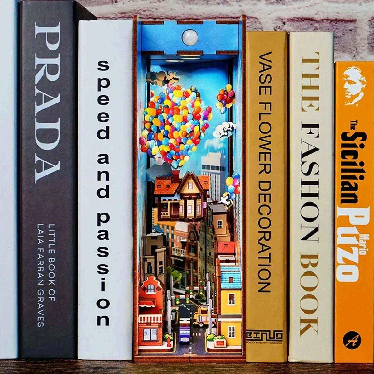 Travel with the Wind book nook between books, showing a balloon-lifted house above a colorful town.