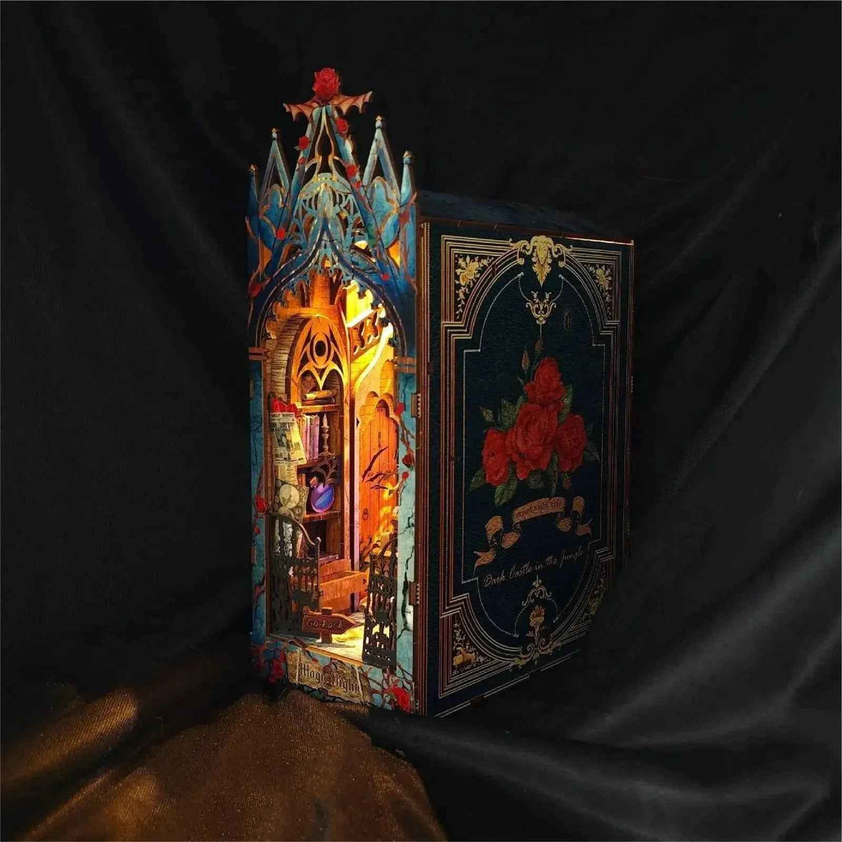 Angled Twilight Castle book nook showing its rose-decorated side panel and glowing interior.