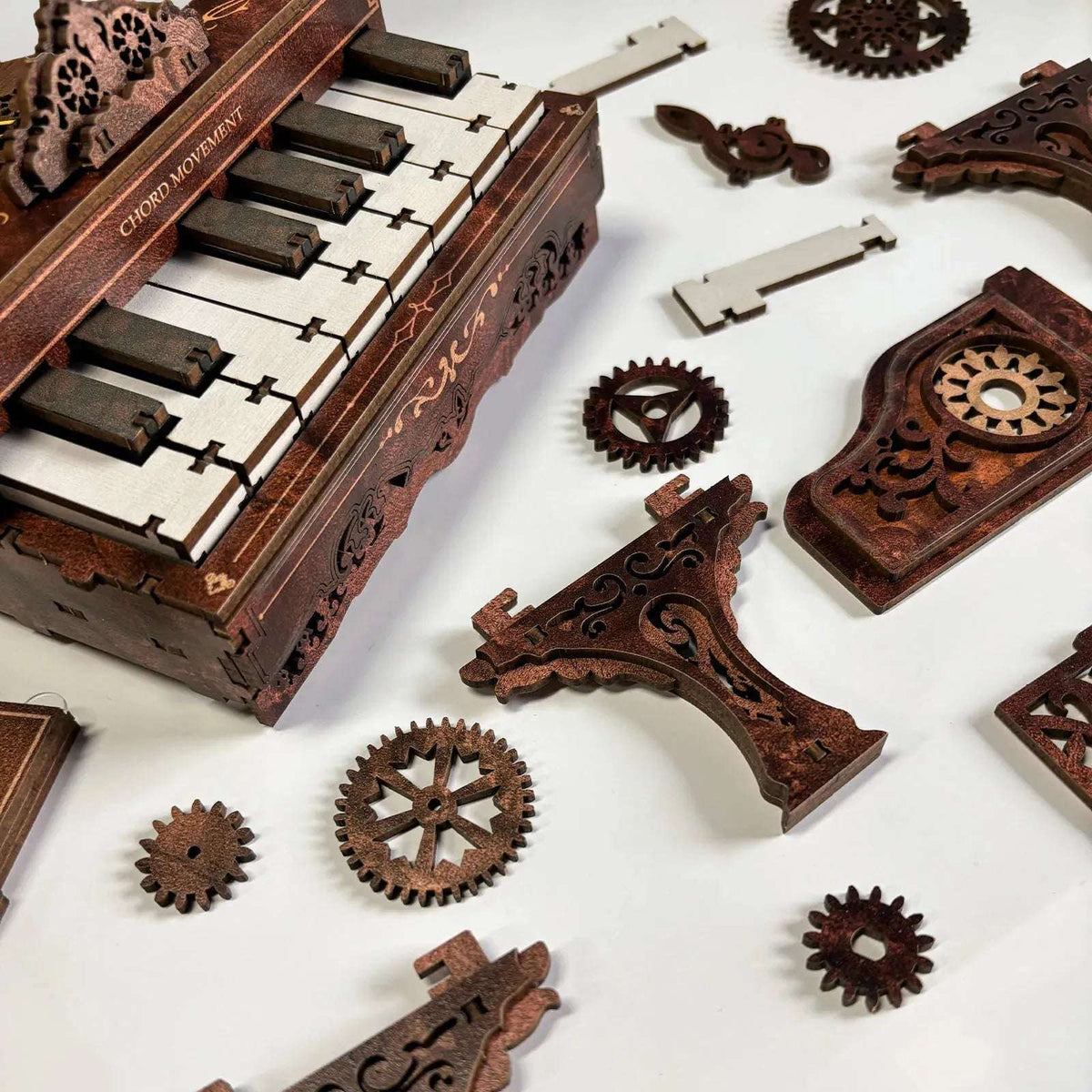 3D Piano keyboard and loose wooden gears, panels and legs laid out for assembly.