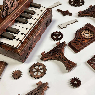 3D Piano keyboard and loose wooden gears, panels and legs laid out for assembly.