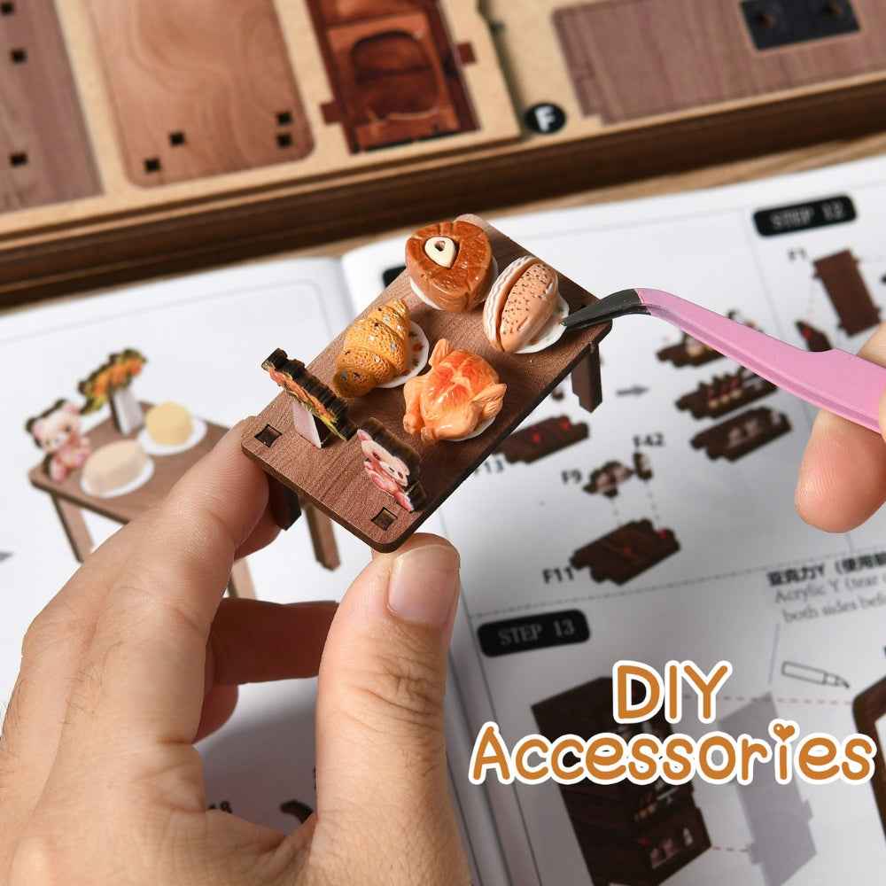 Tweezers placing a miniature bread piece on a Bear Restaurant tray.