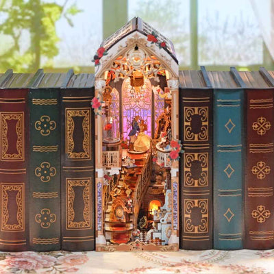 Beast and Beauty book nook between books, with an ornate ballroom and pink-purple window lighting.