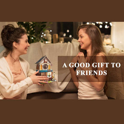 Two women exchanging a completed Cuckoo Clock House model.