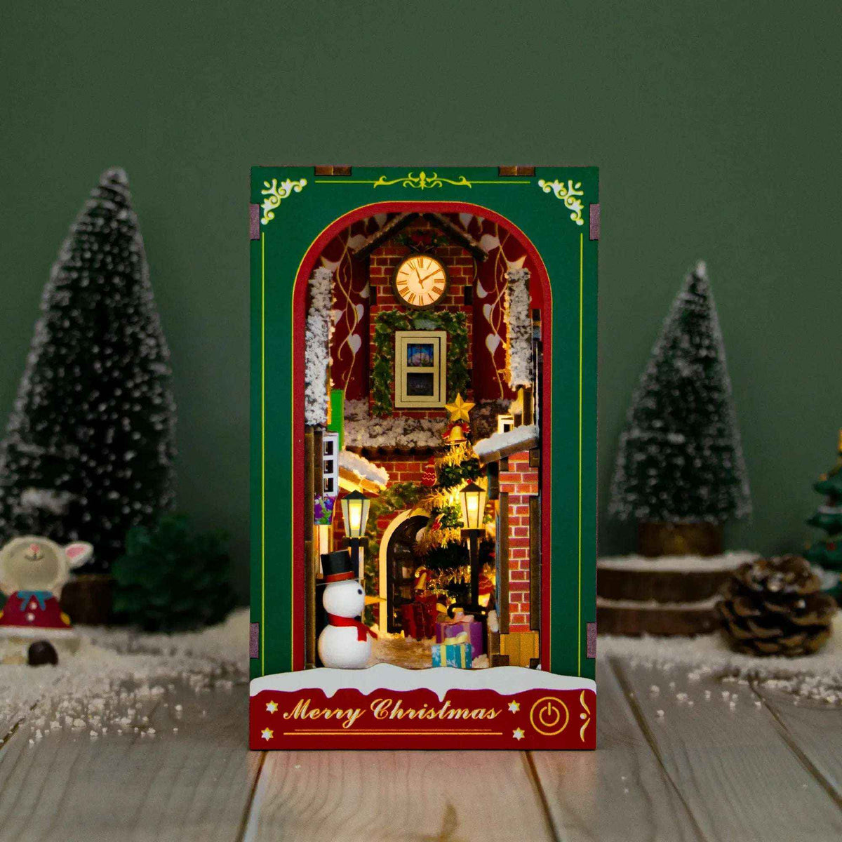Enchanted Christmas book nook with a red-and-green frame, snowy street and miniature snowman.