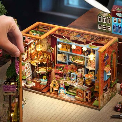 Hand opening Fairy-Tale Wonderhouse to reveal miniature shelves and counters inside.