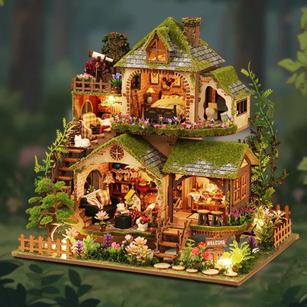 Forest Adventure miniature cottage with moss-like roofs, tiered rooms and a flower-filled garden.