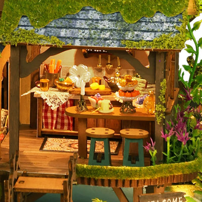 Forest Adventure miniature dining area with a green table and warm lights.