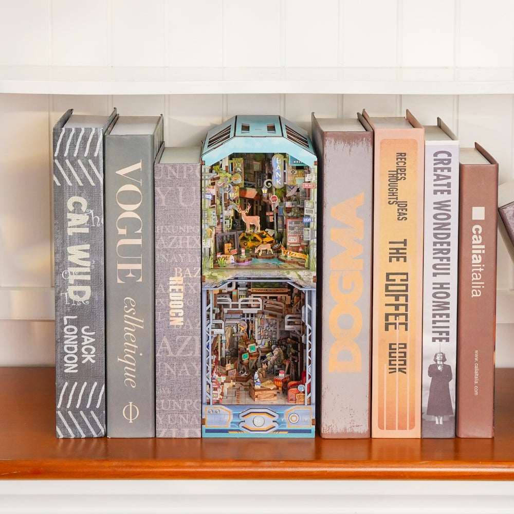 Haven Zero book nook between books, with a pale blue frame and densely furnished miniature rooms.