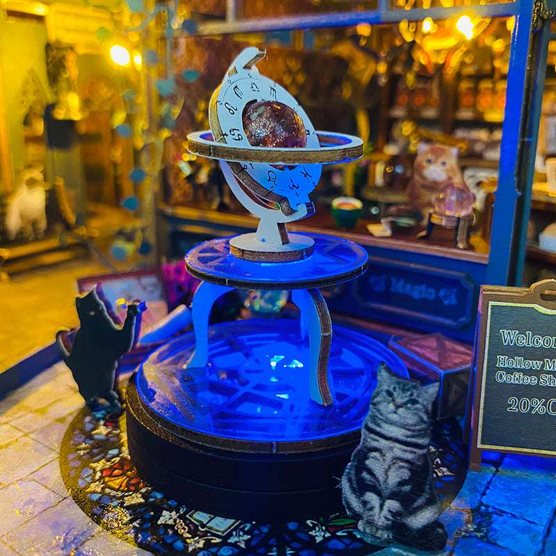 Blue-lit astronomical display and miniature cat figures outside Hollow Magic Coffee Shop.