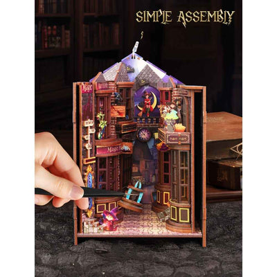 Hand assembling Magic Alley with a side panel open to expose the miniature street.