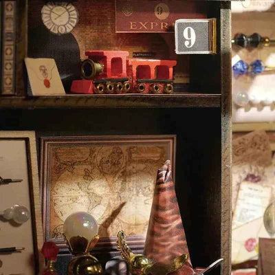 Miniature train on an upper shelf above a map inside Magic House.