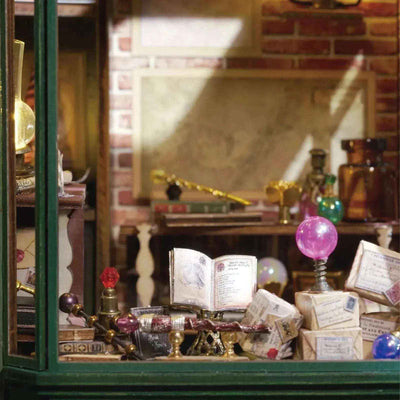 Magic House window display with an open book, potion bottles and purple crystal balls.