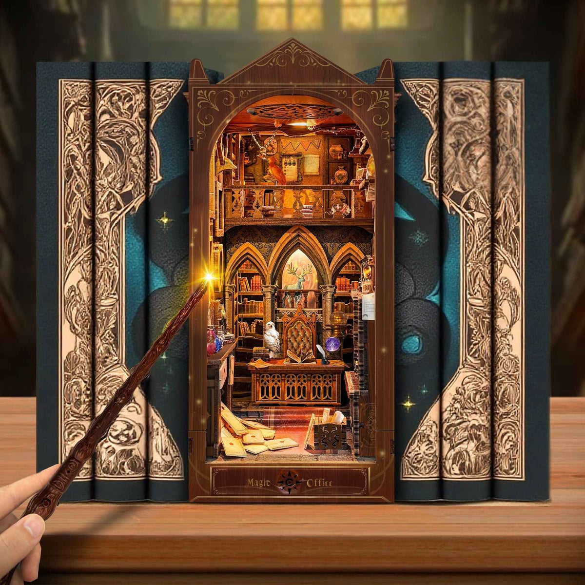 Magic Office book nook between books with a wand aimed toward its warm-lit interior.