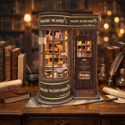 Magic Wand Store on a wooden desk beside books, a quill and an ink bottle.