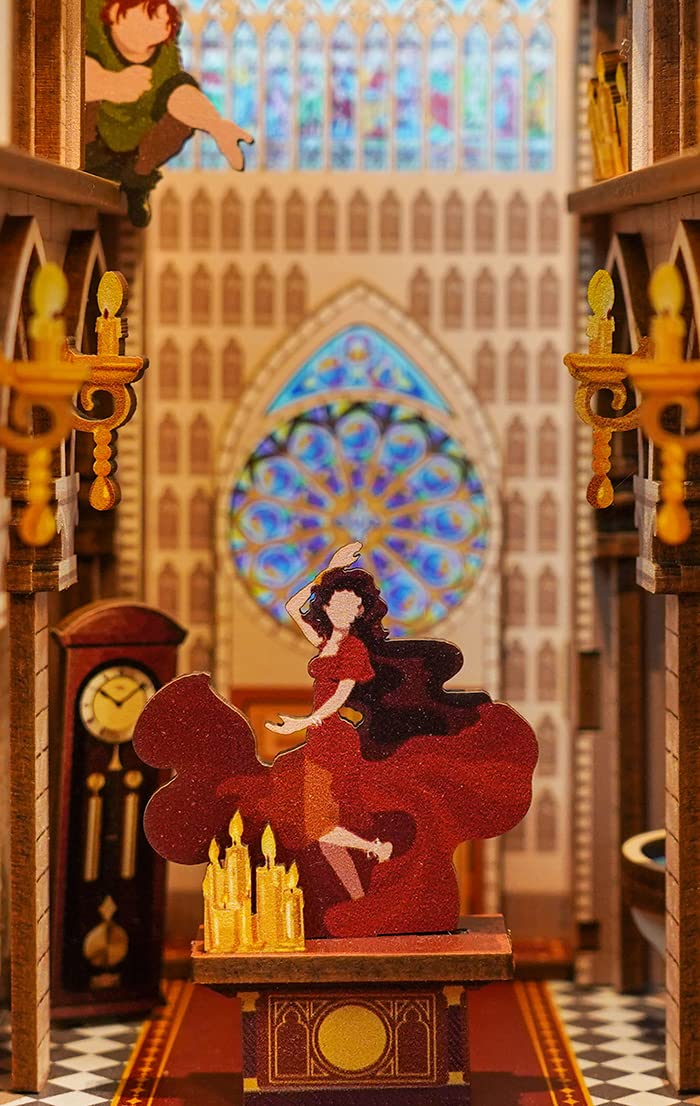 Miniature figures, candles and colorful rose windows inside the Notre-Dame de Paris book nook.