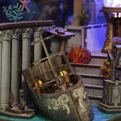 Open treasure chest beside miniature stairs and coral inside Riddle on the Seabed.