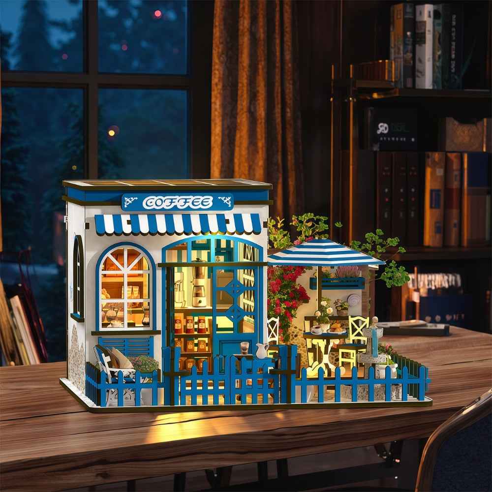 Santorini Sun Coffee miniature café with blue fencing, striped awnings and an outdoor table.