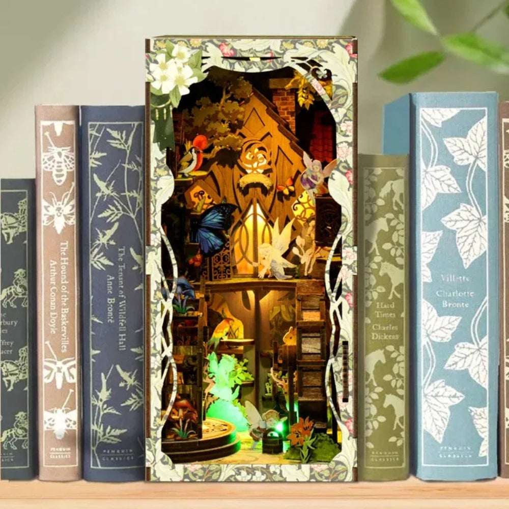 Secret World of the Forest book nook between books, with glowing miniature tree houses and foliage.