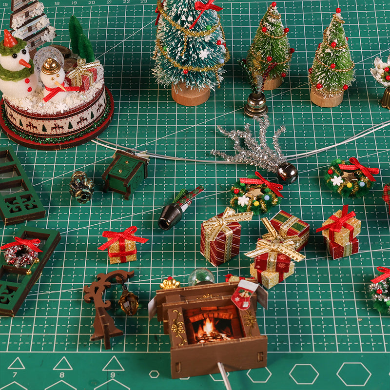 Snowy Christmas Lodge miniature trees, gifts, fireplace and festive accessories on a cutting mat.