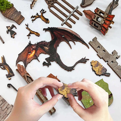 Hands assembling Spirit Valley of the Magic Ring components beside a large dragon cutout.