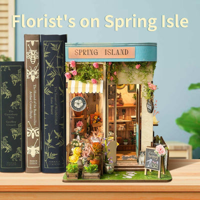 Spring Island flower-shop book nook between books with a turquoise door and climbing flowers.