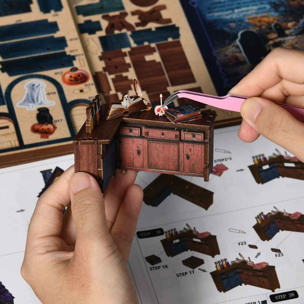 Tweezers placing a small decoration on a cabinet for The Magical Night at the Castle.