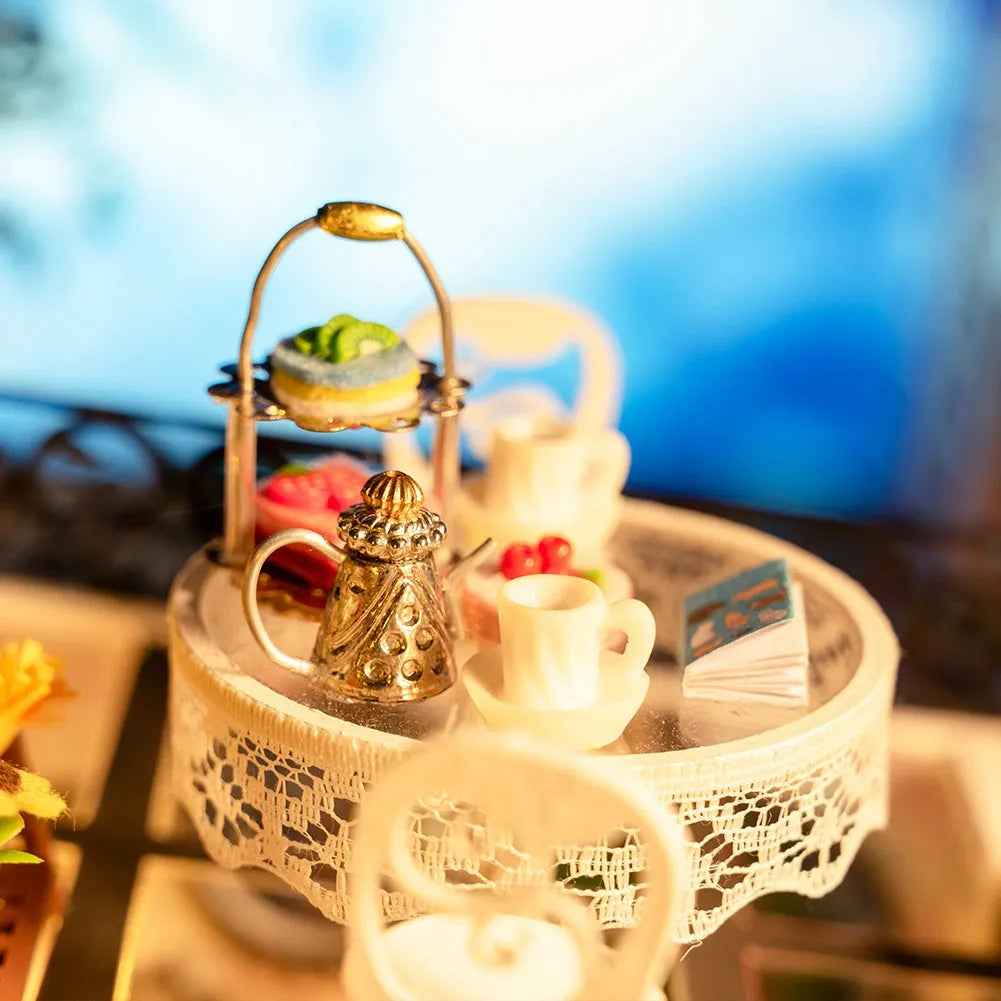 Miniature round tea table with cakes, cups and a teapot inside The Pet Club.