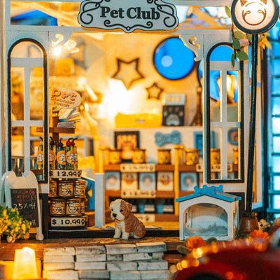 The Pet Club entrance with a small dog, miniature pet house and glowing interior.