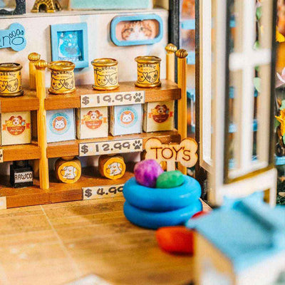 The Pet Club shelves stocked with miniature pet food, with a blue pet bed on the floor.