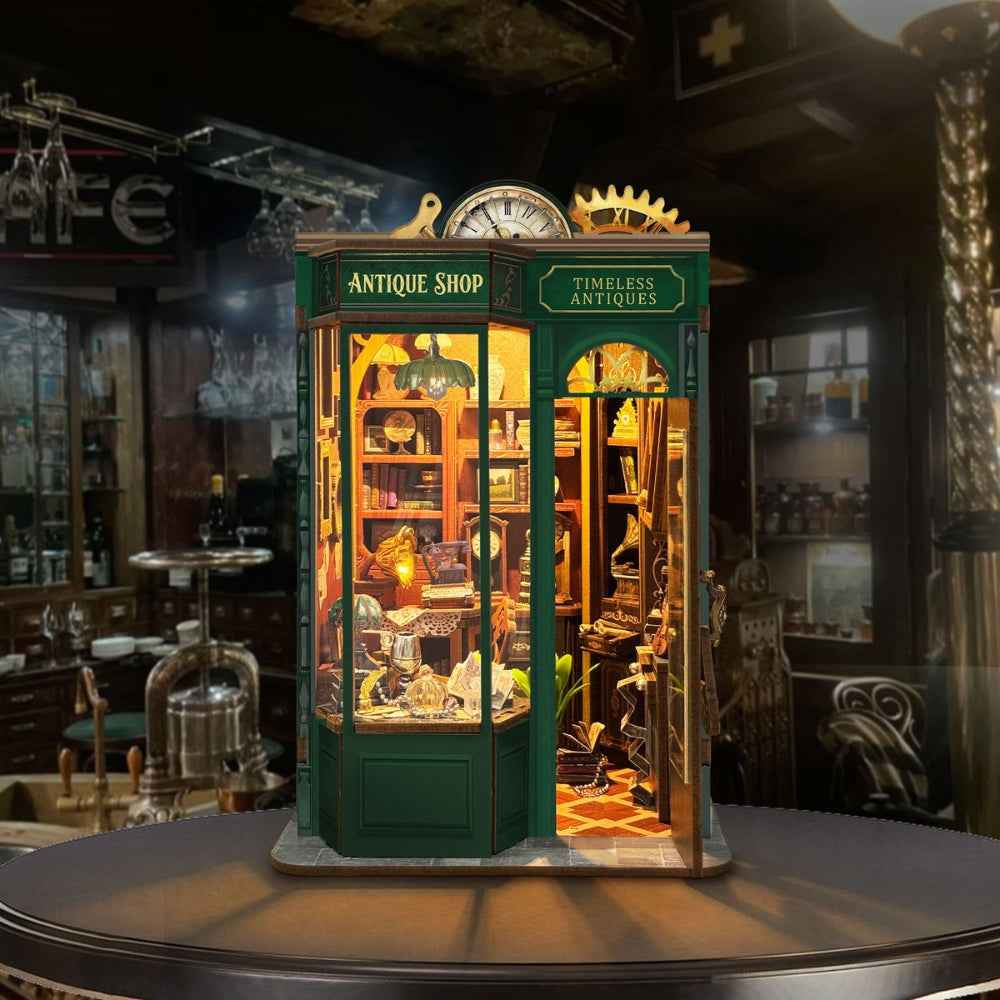 Timeless Antiques green storefront book nook with a curved window and warm-lit displays.