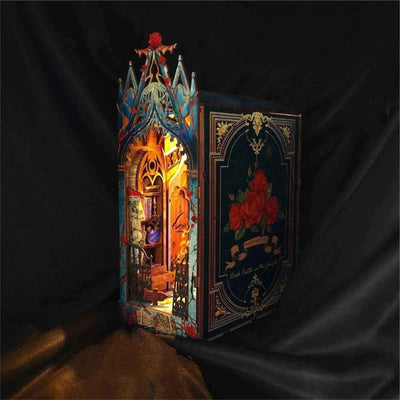 Angled Twilight Castle book nook showing its rose-decorated side panel and glowing interior.