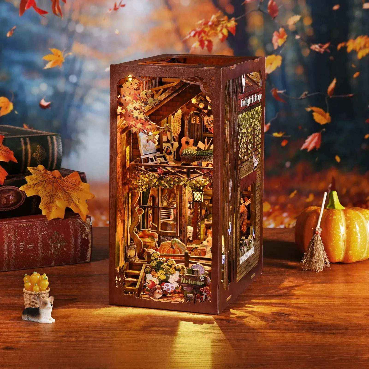 Twilight Cottage autumn book nook beside a pumpkin, with warm lights and orange foliage.