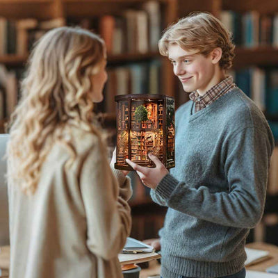 Two people holding a completed Wisdom Rings Books Repository miniature library.