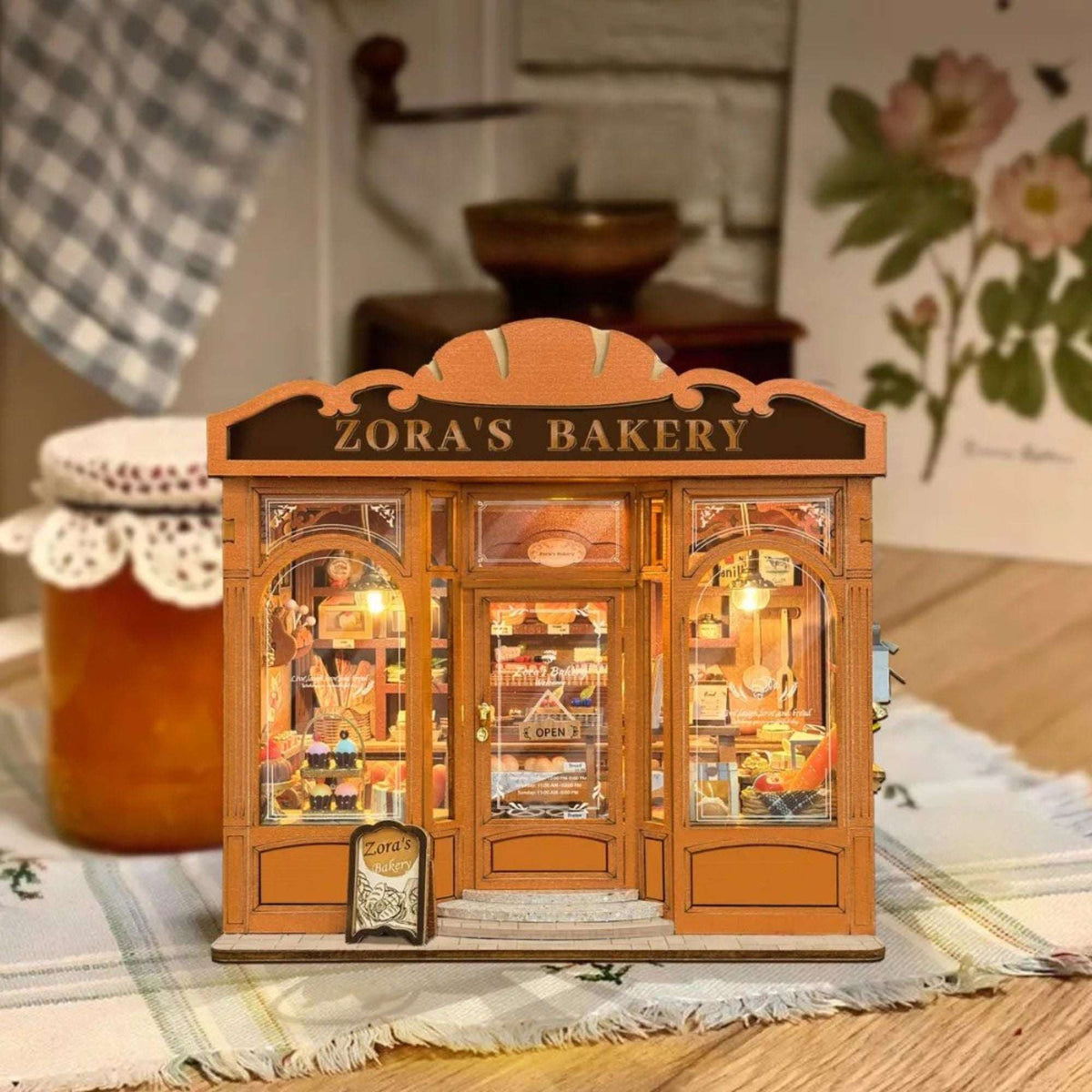 Zora's Bakery miniature storefront with orange trim and warm-lit pastry displays.