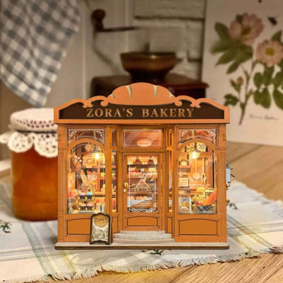 Zora's Bakery miniature storefront with orange trim and warm-lit pastry displays.